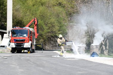 Sarı üniformalı itfaiyeci yağla savaşırken doğal ortamda köpükle ateş edebilir.