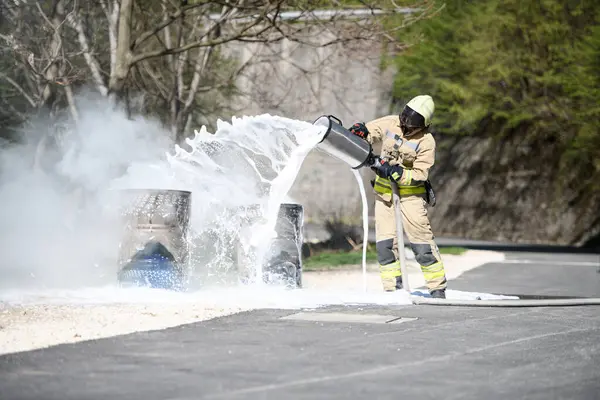 Sarı üniformalı itfaiyeci yağla savaşırken doğal ortamda köpükle ateş edebilir.