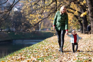 Anne ve Kızı Sonbahar Yaprakları 'nda huzurlu bir yürüyüşün tadını çıkarıyorlar.