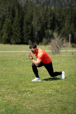 Atletik Adam Ağaçların Arkaplanıyla Çimlere Çıkıyor