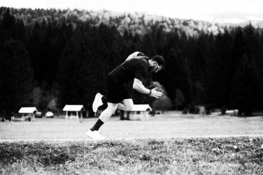 Fitness Coşkusu Dağlarla baş döndürücü bir doğal ortam ve arkasında bir orman olan açık hava egzersizinde eğleniyor.