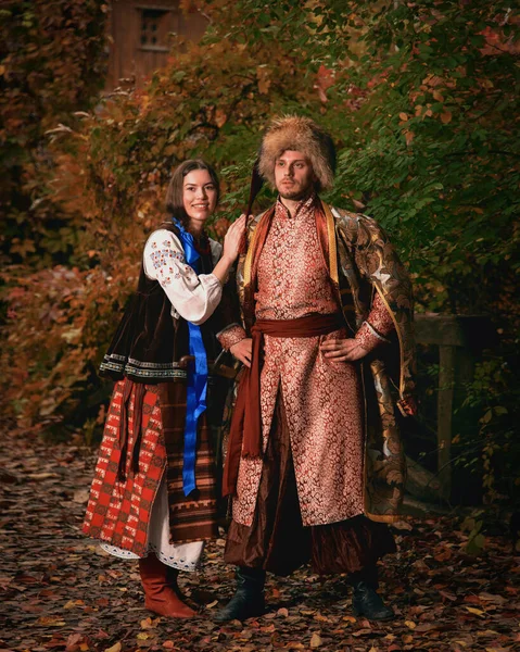 若い笑顔のカップルは伝統的なウクライナの服を着ていた 屋外で刺繍された衣装でコサック男と女 ヴィンテージの衣装 — ストック写真