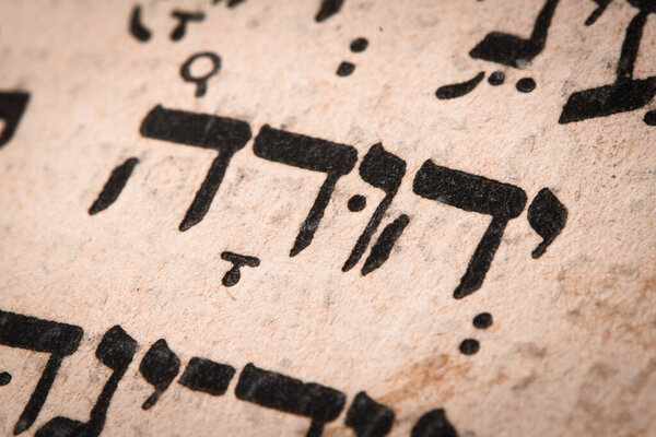 Hebrew word in Torah page. English translation is name Judah, the founder of the Israelite Tribe of Judah. Fourth of the six sons of Jacob and Leah. Selective focus. Closeup