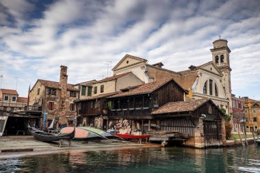 İtalya 'nın Venedik şehrinde bulutlu bir akşamda San Giorgio Maggiore' a karşı San Marco havzasında demirlemiş geleneksel gondollar.