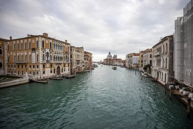 İtalya 'nın Venedik şehrinde bulutlu bir akşamda San Giorgio Maggiore' a karşı San Marco havzasında demirlemiş geleneksel gondollar.