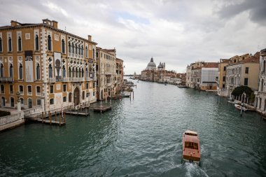 İtalya 'nın Venedik şehrinde bulutlu bir akşamda San Giorgio Maggiore' a karşı San Marco havzasında demirlemiş geleneksel gondollar.