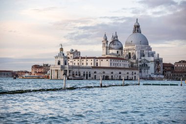 İtalya 'nın Venedik şehrinde bulutlu bir akşamda San Giorgio Maggiore' a karşı San Marco havzasında demirlemiş geleneksel gondollar.