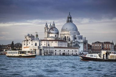 İtalya 'nın Venedik şehrinde bulutlu bir akşamda San Giorgio Maggiore' a karşı San Marco havzasında demirlemiş geleneksel gondollar.