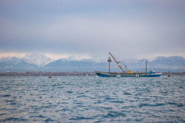 İtalya 'nın Venedik şehrinde bulutlu bir akşamda San Giorgio Maggiore' a karşı San Marco havzasında demirlemiş geleneksel gondollar.