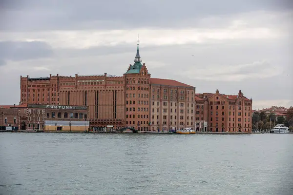 stock image Row of traditional gondolas moored near pier in San Marco basin against San Giorgio Maggiore on island in cloudy evening in Venice, Italy