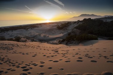 Patara plajı Türkiye 'de ünlü bir turizm merkezi ve doğal varış yeridir. Turuncu kum tepelerinin ve tepelerin görkemli manzarası ılık günbatımının ışınlarında parlıyor..