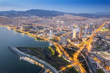 Akşamları İzmir 'de. İzmir Horbour ve İzmir 'in merkezinde yeni gökdelenler. Şehir ışıklarının ve otoyolun uzun pozu.