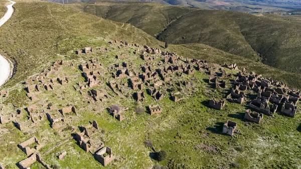 Stock image An abondoned village is Sazak Village in Karaburun /Turkey. Wind tribunes on the background.