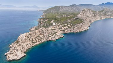 Aerial drone photo of beautiful and picturesque cape Melagavi forming a small peninsula with unique lighthouse stand out next to archaeological site of Heraion, Loutraki, Greece clipart