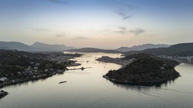 Yunanistan 'ın Saronik Körfezi' ndeki Poros Adası 'nın havacılık manzarası, renkli bir yaz günbatımında