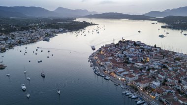 Yunanistan 'ın Saronik Körfezi' ndeki Poros Adası 'nın havacılık manzarası, renkli bir yaz günbatımında