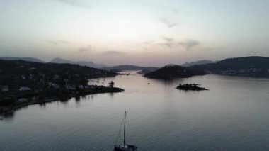 Yunanistan 'ın Saronik Körfezi' ndeki Poros Adası 'nın havacılık manzarası, renkli bir yaz günbatımında