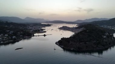 Yunanistan 'ın Saronik Körfezi' ndeki Poros Adası 'nın havacılık manzarası, renkli bir yaz günbatımında