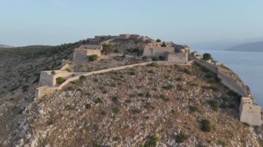 Yunanistan 'da Nafplion şehrinin bulunduğu yeşil yarımada mavi Akdeniz, eski kasaba çatıları ve küçük liman