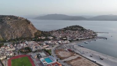 Yunanistan 'da Nafplion şehrinin bulunduğu yeşil yarımada mavi Akdeniz, eski kasaba çatıları ve küçük liman