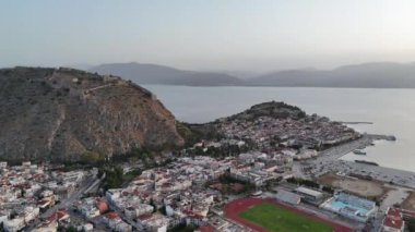Yunanistan 'da Nafplion şehrinin bulunduğu yeşil yarımada mavi Akdeniz, eski kasaba çatıları ve küçük liman