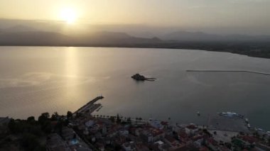 Yunanistan 'da Nafplion şehrinin bulunduğu yeşil yarımada mavi Akdeniz, eski kasaba çatıları ve küçük liman