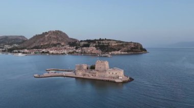 Yunanistan 'da Nafplion şehrinin bulunduğu yeşil yarımada mavi Akdeniz, eski kasaba çatıları ve küçük liman