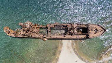 Dimitrios 'un Gythio, Yunanistan' daki gemi enkazının havadan çekilmiş fotoğrafı. Güneşli bir günde kumlu bir sahilde kısmen paslı bir metal gemi enkazı çürüyor. Yunanistan 'ın ünlü gemi enkazı.