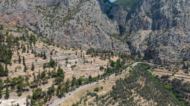 Delphi, Phocis / Yunanistan. Delphi Antik Tiyatrosu. 5.000 seyirci kapasiteli tiyatro Apollo 'nun sığınağında yer almaktadır. Güneşli bir günde bulutlu bir gökyüzü ile panoramik manzara