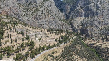 Delphi, Phocis / Yunanistan. Delphi Antik Tiyatrosu. 5.000 seyirci kapasiteli tiyatro Apollo 'nun sığınağında yer almaktadır. Güneşli bir günde bulutlu bir gökyüzü ile panoramik manzara