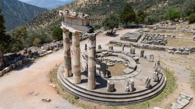 Delphi, Phocis / Yunanistan. Delphi Antik Tiyatrosu. 5.000 seyirci kapasiteli tiyatro Apollo 'nun sığınağında yer almaktadır. Güneşli bir günde bulutlu bir gökyüzü ile panoramik manzara