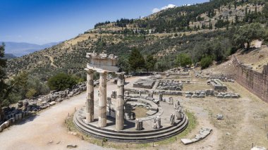 Delphi, Phocis / Yunanistan. Delphi Antik Tiyatrosu. 5.000 seyirci kapasiteli tiyatro Apollo 'nun sığınağında yer almaktadır. Güneşli bir günde bulutlu bir gökyüzü ile panoramik manzara