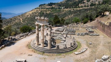 Delphi, Phocis / Yunanistan. Delphi Antik Tiyatrosu. 5.000 seyirci kapasiteli tiyatro Apollo 'nun sığınağında yer almaktadır. Güneşli bir günde bulutlu bir gökyüzü ile panoramik manzara