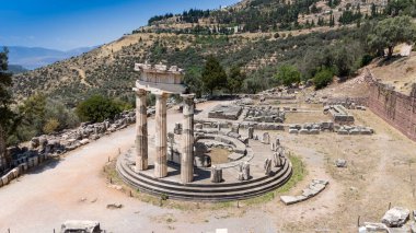 Delphi, Phocis / Yunanistan. Delphi Antik Tiyatrosu. 5.000 seyirci kapasiteli tiyatro Apollo 'nun sığınağında yer almaktadır. Güneşli bir günde bulutlu bir gökyüzü ile panoramik manzara