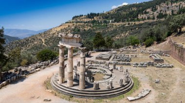 Delphi, Phocis / Yunanistan. Delphi Antik Tiyatrosu. 5.000 seyirci kapasiteli tiyatro Apollo 'nun sığınağında yer almaktadır. Güneşli bir günde bulutlu bir gökyüzü ile panoramik manzara
