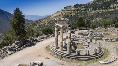 Delphi, Phocis / Yunanistan. Delphi Antik Tiyatrosu. 5.000 seyirci kapasiteli tiyatro Apollo 'nun sığınağında yer almaktadır. Güneşli bir günde bulutlu bir gökyüzü ile panoramik manzara