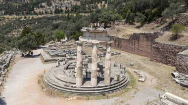 Delphi, Phocis / Yunanistan. Delphi Antik Tiyatrosu. 5.000 seyirci kapasiteli tiyatro Apollo 'nun sığınağında yer almaktadır. Güneşli bir günde bulutlu bir gökyüzü ile panoramik manzara
