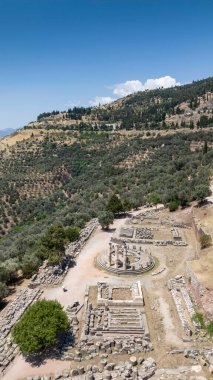 Delphi, Phocis / Yunanistan. Delphi Antik Tiyatrosu. 5.000 seyirci kapasiteli tiyatro Apollo 'nun sığınağında yer almaktadır. Güneşli bir günde bulutlu bir gökyüzü ile panoramik manzara