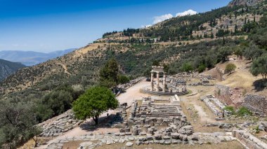 Delphi, Phocis / Yunanistan. Delphi Antik Tiyatrosu. 5.000 seyirci kapasiteli tiyatro Apollo 'nun sığınağında yer almaktadır. Güneşli bir günde bulutlu bir gökyüzü ile panoramik manzara