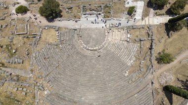 Delphi, Phocis / Yunanistan. Delphi Antik Tiyatrosu. 5.000 seyirci kapasiteli tiyatro Apollo 'nun sığınağında yer almaktadır. Güneşli bir günde bulutlu bir gökyüzü ile panoramik manzara