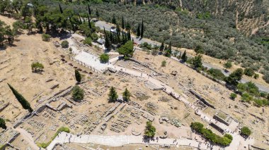 Delphi, Phocis / Yunanistan. Delphi Antik Tiyatrosu. 5.000 seyirci kapasiteli tiyatro Apollo 'nun sığınağında yer almaktadır. Güneşli bir günde bulutlu bir gökyüzü ile panoramik manzara