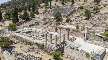 Delphi, Phocis / Yunanistan. Delphi Antik Tiyatrosu. 5.000 seyirci kapasiteli tiyatro Apollo 'nun sığınağında yer almaktadır. Güneşli bir günde bulutlu bir gökyüzü ile panoramik manzara
