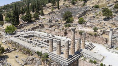 Delphi, Phocis / Yunanistan. Delphi Antik Tiyatrosu. 5.000 seyirci kapasiteli tiyatro Apollo 'nun sığınağında yer almaktadır. Güneşli bir günde bulutlu bir gökyüzü ile panoramik manzara