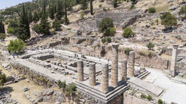 Delphi, Phocis / Yunanistan. Delphi Antik Tiyatrosu. 5.000 seyirci kapasiteli tiyatro Apollo 'nun sığınağında yer almaktadır. Güneşli bir günde bulutlu bir gökyüzü ile panoramik manzara