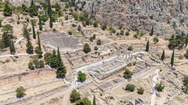 Delphi, Phocis / Yunanistan. Delphi Antik Tiyatrosu. 5.000 seyirci kapasiteli tiyatro Apollo 'nun sığınağında yer almaktadır. Güneşli bir günde bulutlu bir gökyüzü ile panoramik manzara