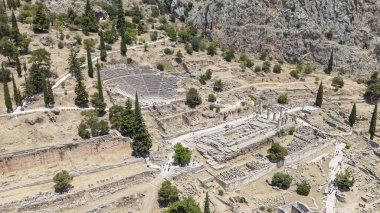 Delphi, Phocis / Yunanistan. Delphi Antik Tiyatrosu. 5.000 seyirci kapasiteli tiyatro Apollo 'nun sığınağında yer almaktadır. Güneşli bir günde bulutlu bir gökyüzü ile panoramik manzara