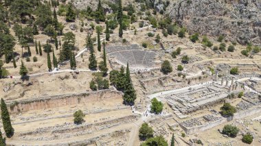 Delphi, Phocis / Yunanistan. Delphi Antik Tiyatrosu. 5.000 seyirci kapasiteli tiyatro Apollo 'nun sığınağında yer almaktadır. Güneşli bir günde bulutlu bir gökyüzü ile panoramik manzara