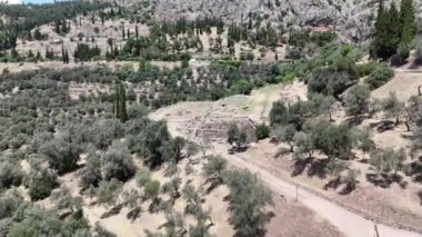 Delphi, Phocis / Yunanistan. Delphi Antik Tiyatrosu. 5.000 seyirci kapasiteli tiyatro Apollo 'nun sığınağında yer almaktadır. Güneşli bir günde bulutlu bir gökyüzü ile panoramik manzara
