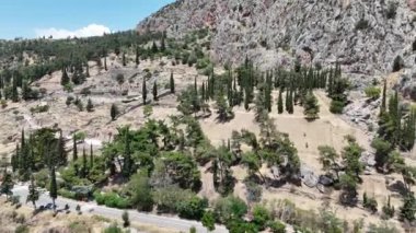 Delphi, Phocis / Yunanistan. Delphi Antik Tiyatrosu. 5.000 seyirci kapasiteli tiyatro Apollo 'nun sığınağında yer almaktadır. Güneşli bir günde bulutlu bir gökyüzü ile panoramik manzara