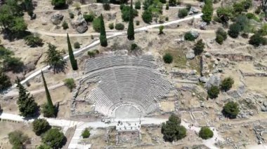 Delphi, Phocis / Yunanistan. Delphi Antik Tiyatrosu. 5.000 seyirci kapasiteli tiyatro Apollo 'nun sığınağında yer almaktadır. Güneşli bir günde bulutlu bir gökyüzü ile panoramik manzara